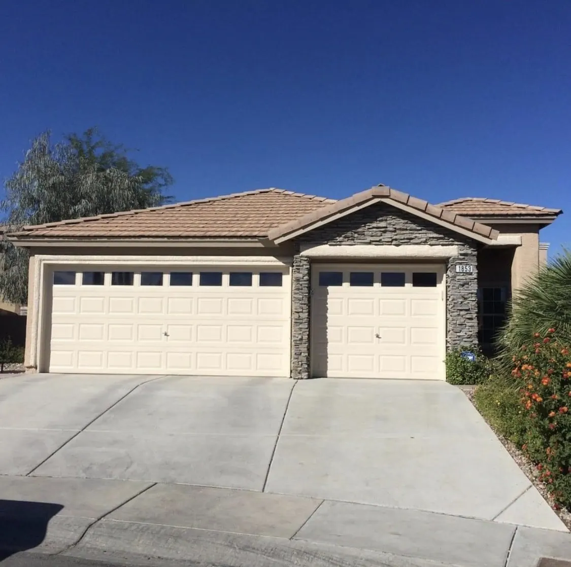 Completed exterior repaint with cream stucco and stacked stone accents on an Enterprise Las Vegas NV home by MK Painting