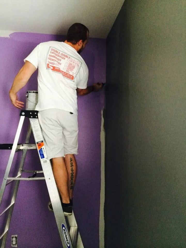 MK Painting crew cutting in a purple accent wall against charcoal in a Las Vegas game room
