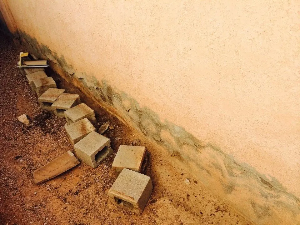 Before: damaged and water-stained stucco wall base in Las Vegas prior to repair by MK Painting